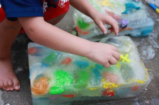 Kid playing ice block treasure hunt outside activity