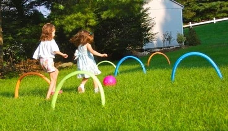 Kids playing kick croquet game outside