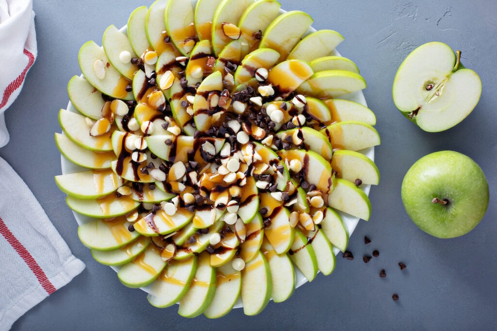 Apple nachos with white and dark chocolate chips, caramel syrup and almonds