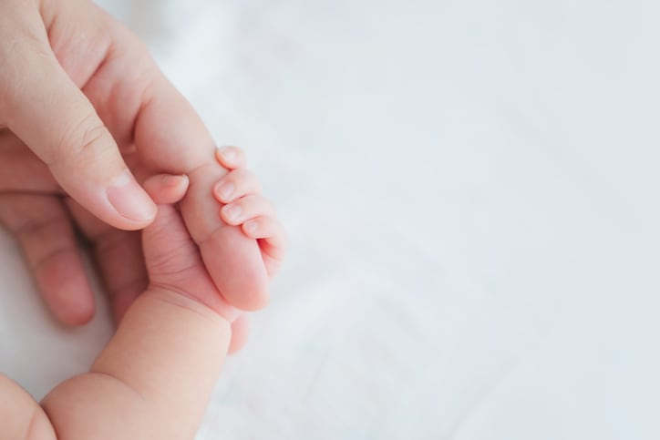 newborn holding mom hand