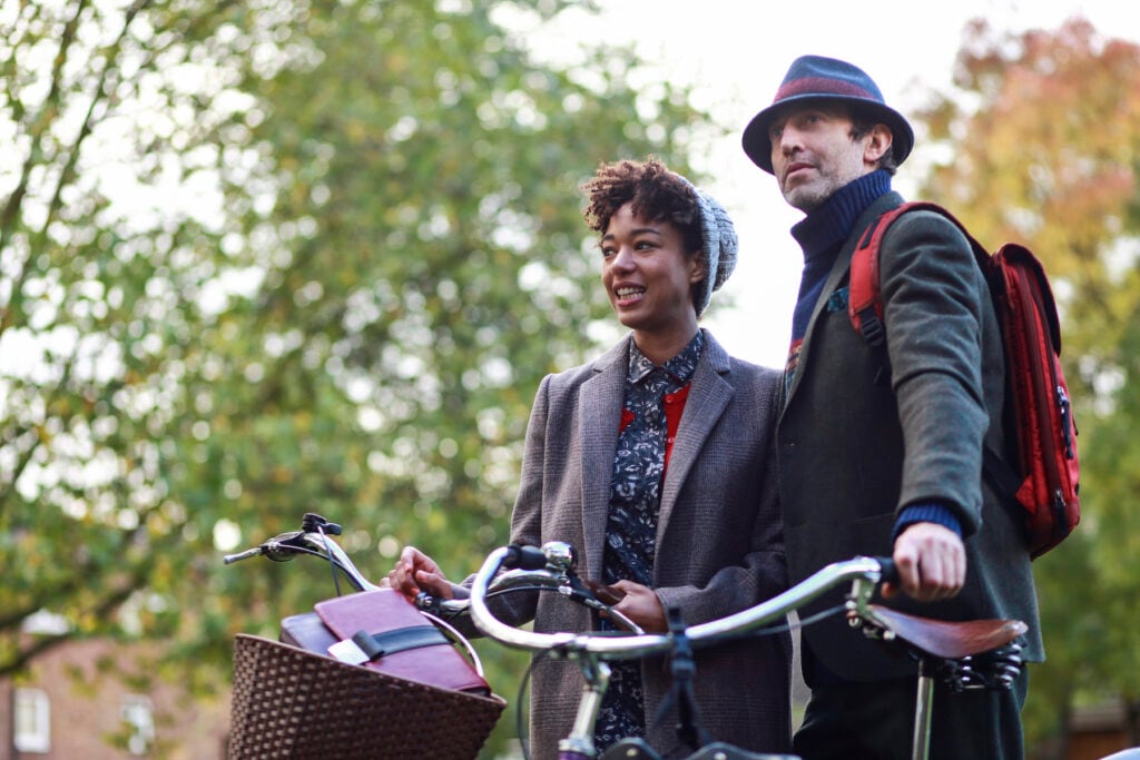 Couple riding on bicycles and talking on a cheap date night