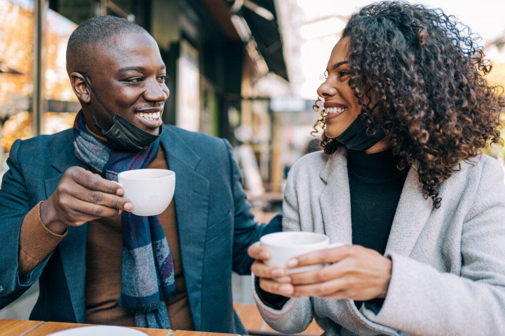 Adorable young couple drinking coffee together in city cafe on a cheap date night