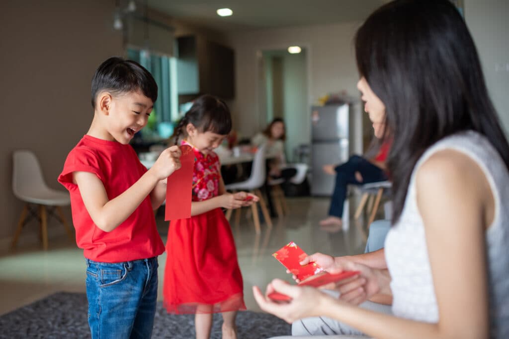 Happy kids receive red envelopes from their parent during Lunar New Year