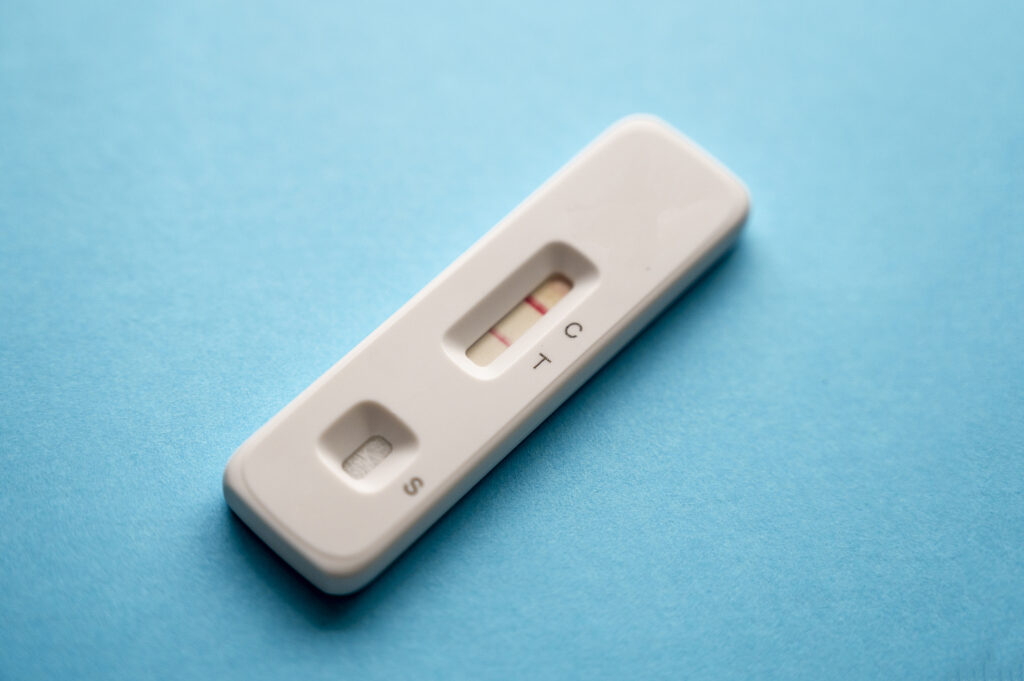 Coronavirus COVID antigen rapid test with a positive result on blue background