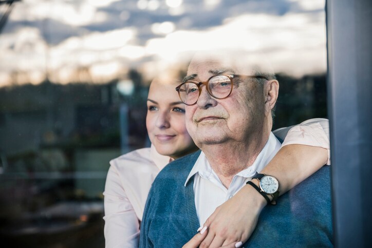 ortrait of young woman embracing senior man at the window